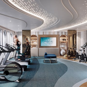 a room with a gym and a woman running on treadmills