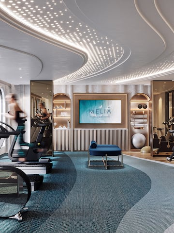a room with a gym and a woman running on treadmills