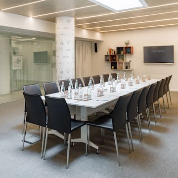 a conference room with a table with chairs and bottles of water