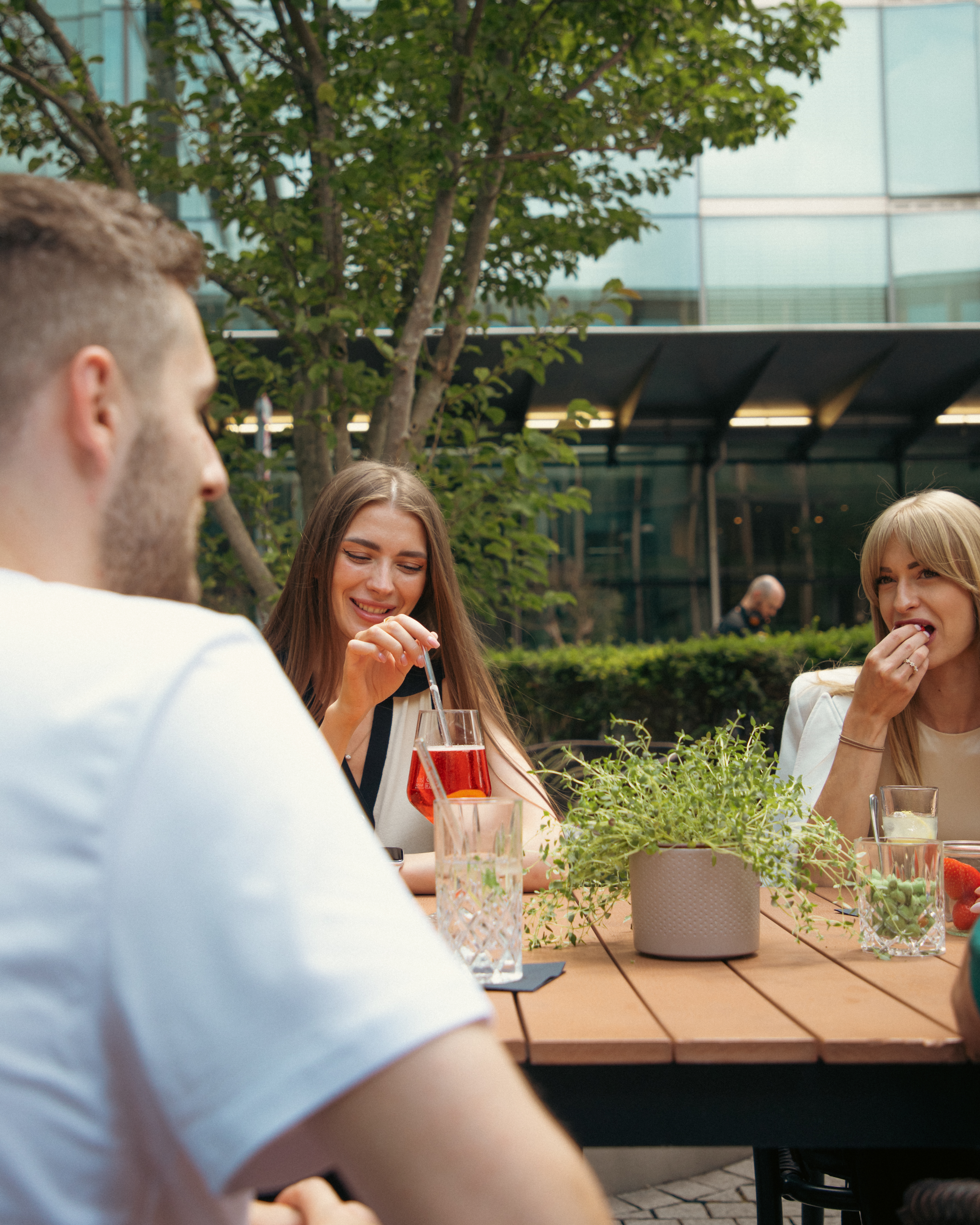 Friends enjoying drinks and snacks on an outdoor patio.