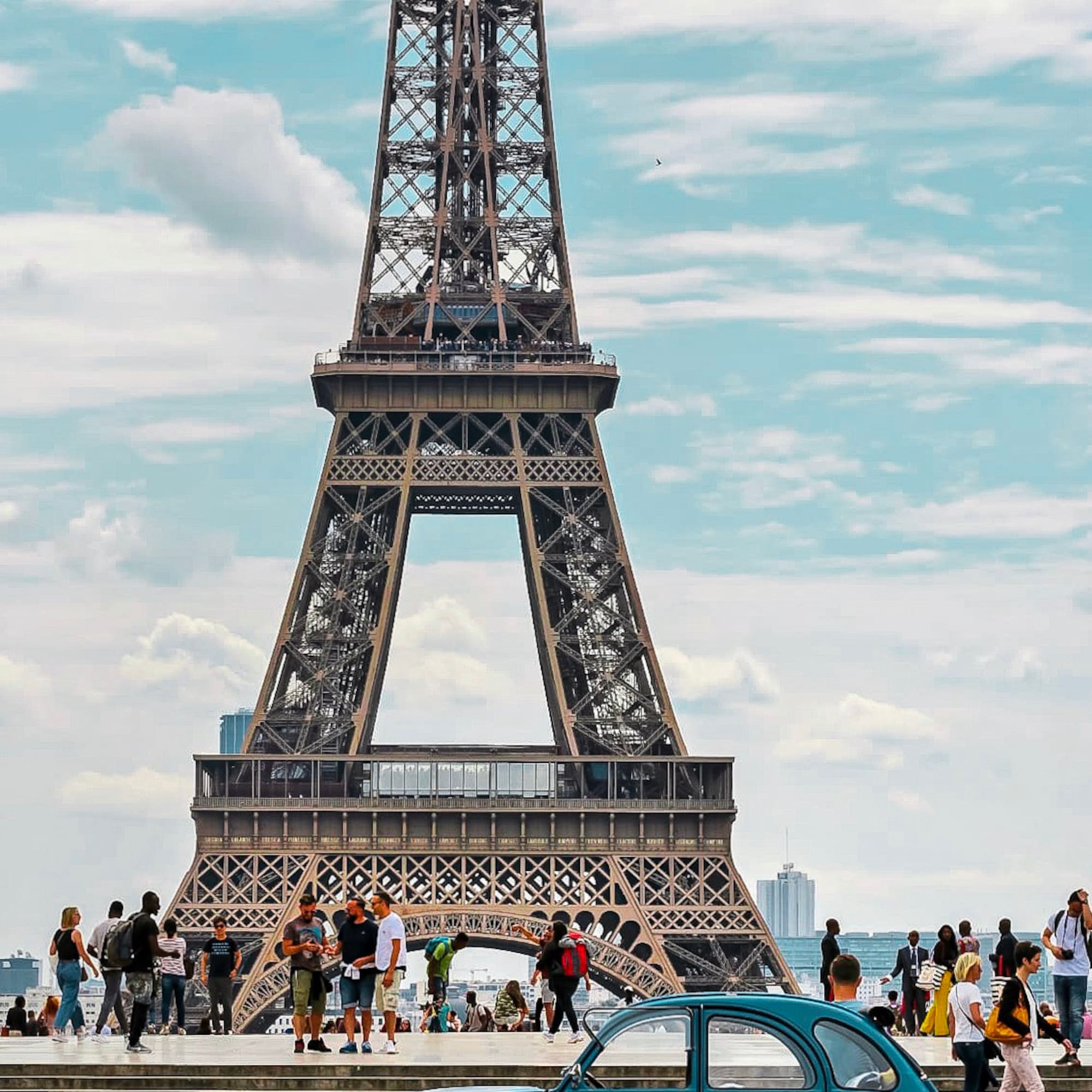 a group of people standing near a monument with Eiffel Tower in the background