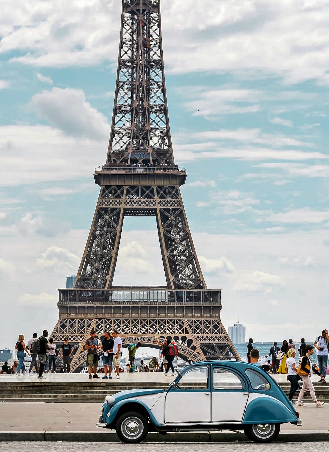 a group of people standing near a monument with Eiffel Tower in the background