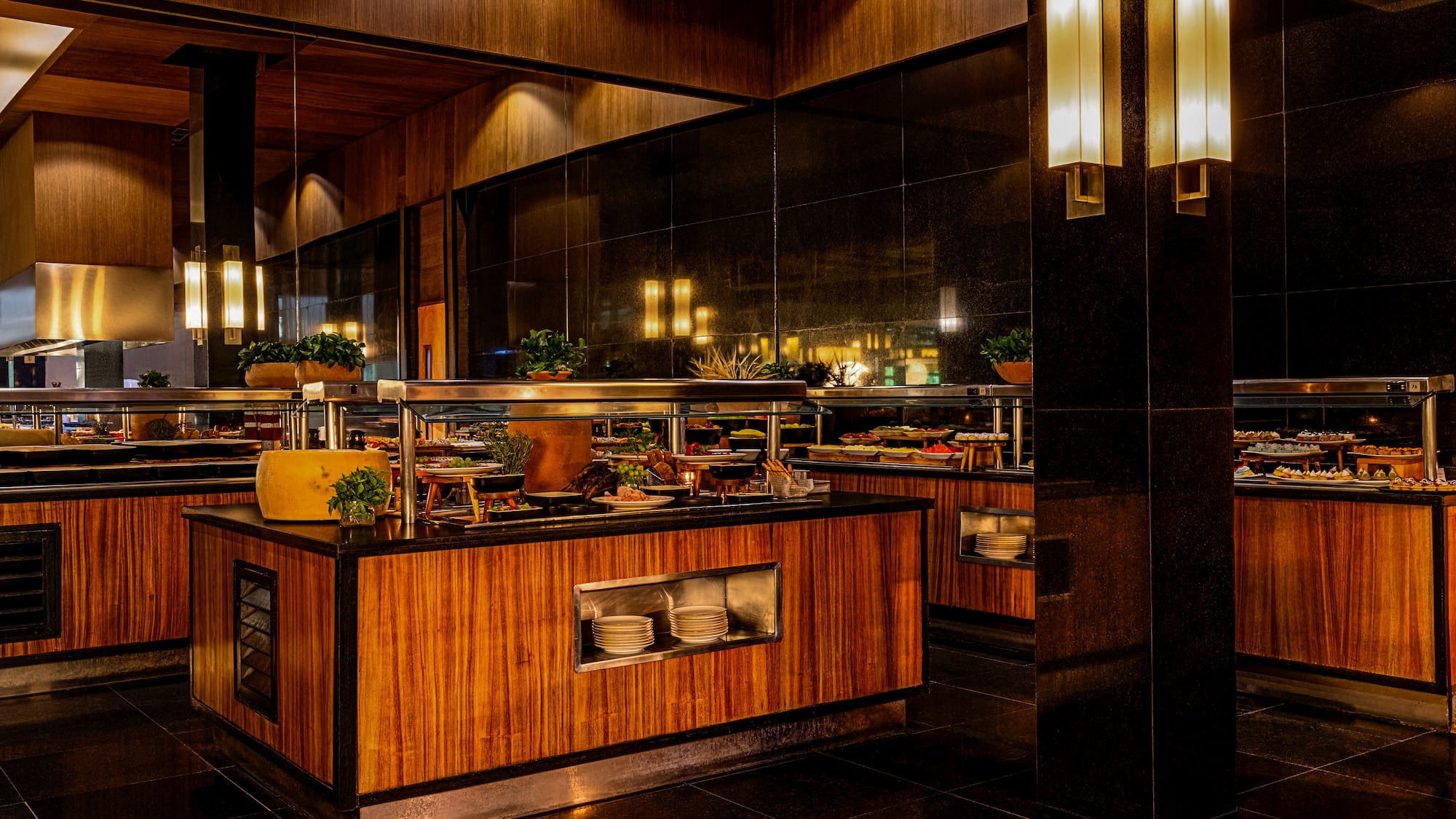 Elegant restaurant buffet with various food, dark wood, and warm lighting.