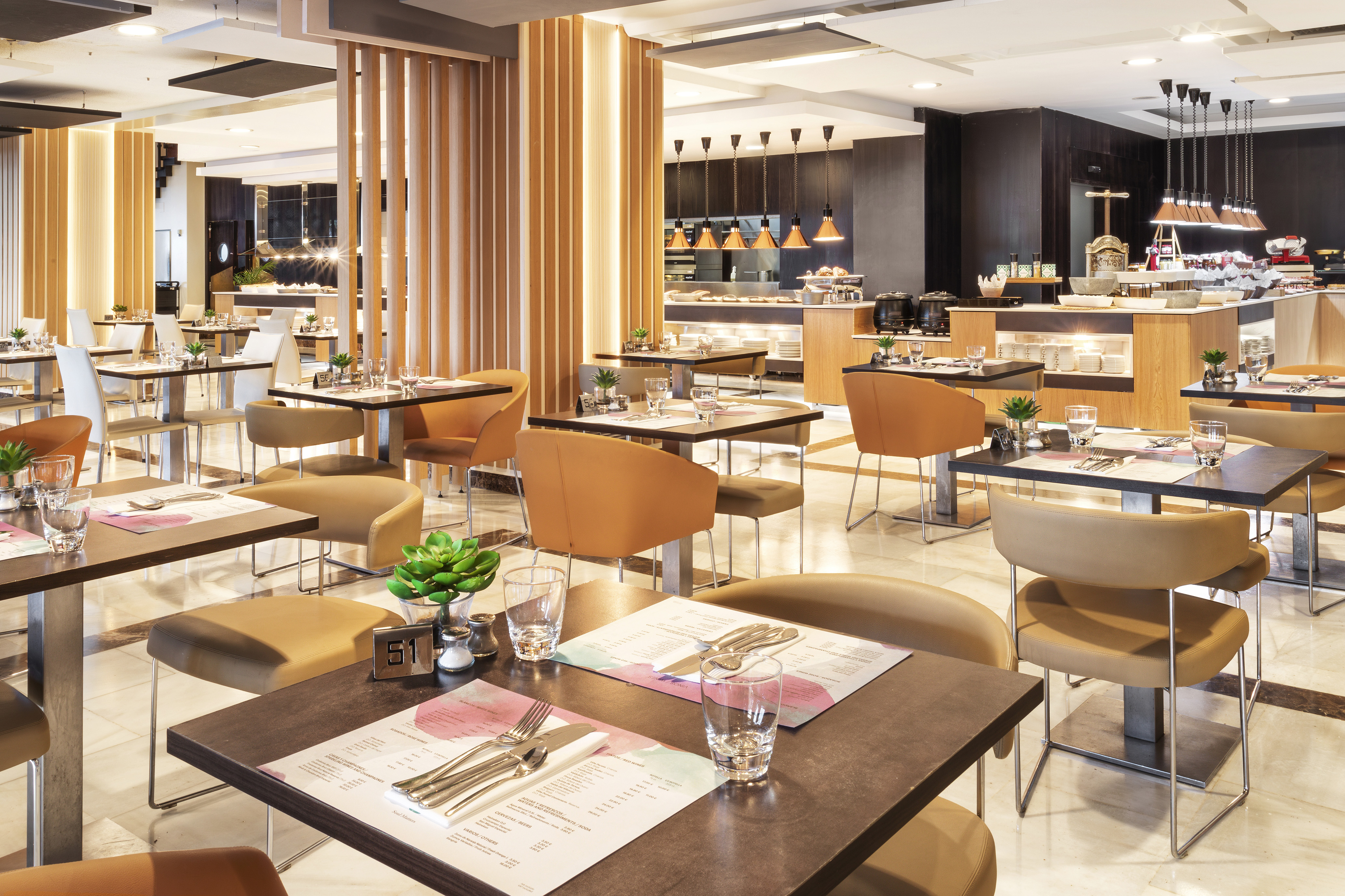 Contemporary hotel restaurant with set dining tables and a buffet.