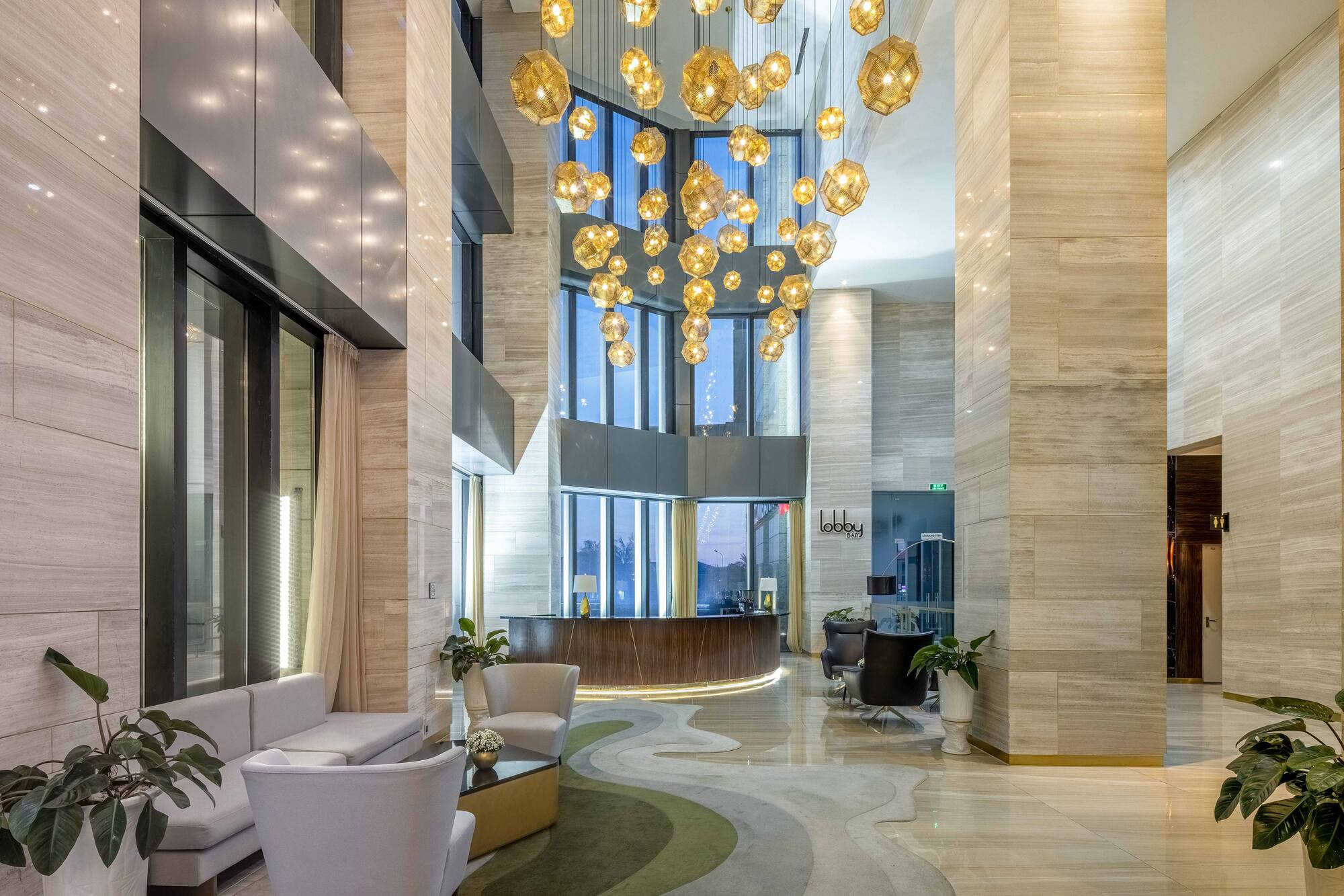 a lobby with a large chandelier and a reception area