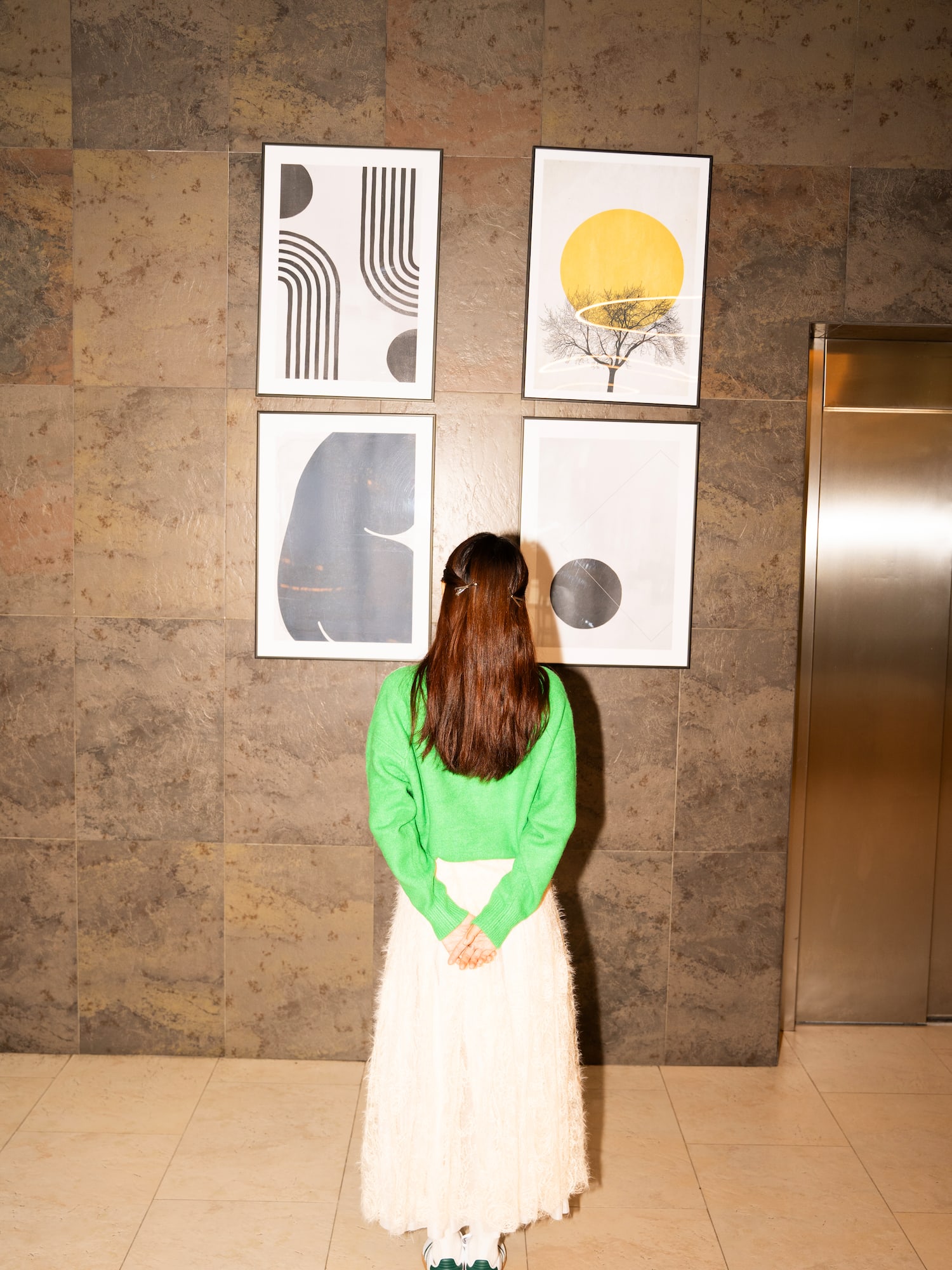 a woman looking at art on the wall