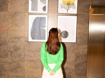 a woman looking at art on the wall