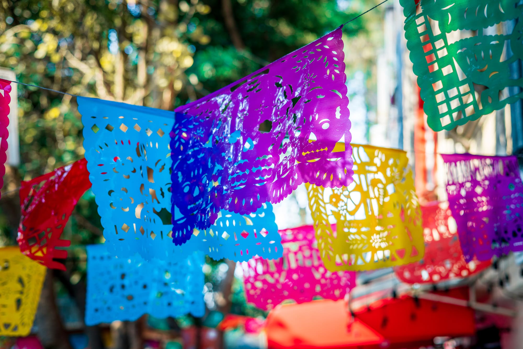 Colorido papel picado mexicano con diseños y calaveras festivas.