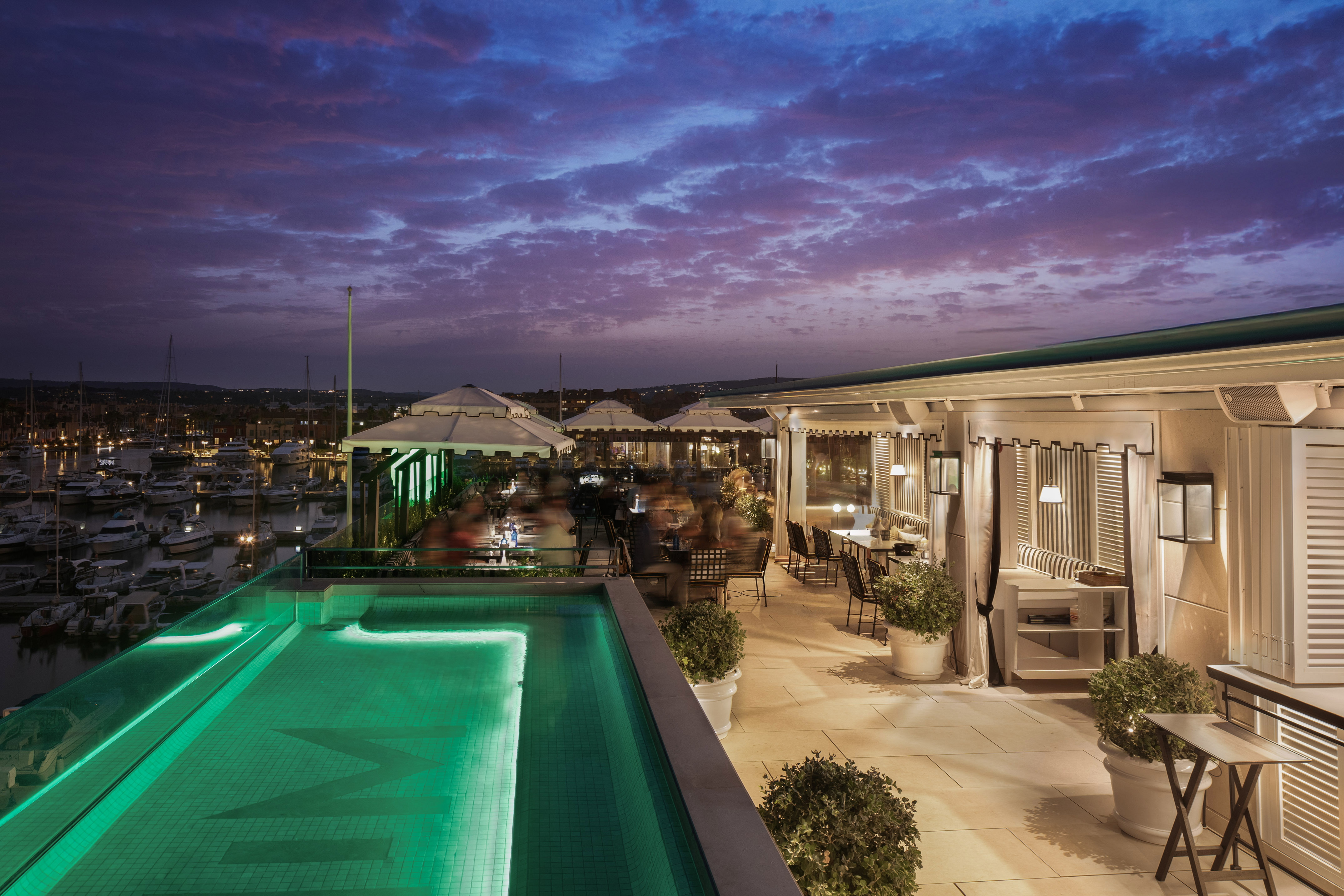 a pool on a rooftop with people sitting around it
