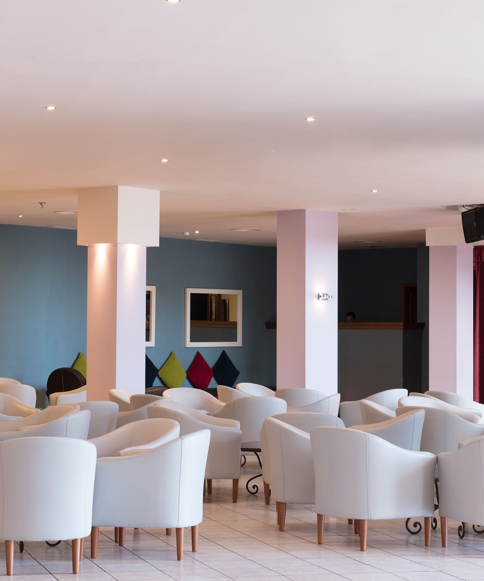 a room with white chairs and red curtains