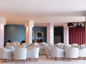 a room with white chairs and red curtains