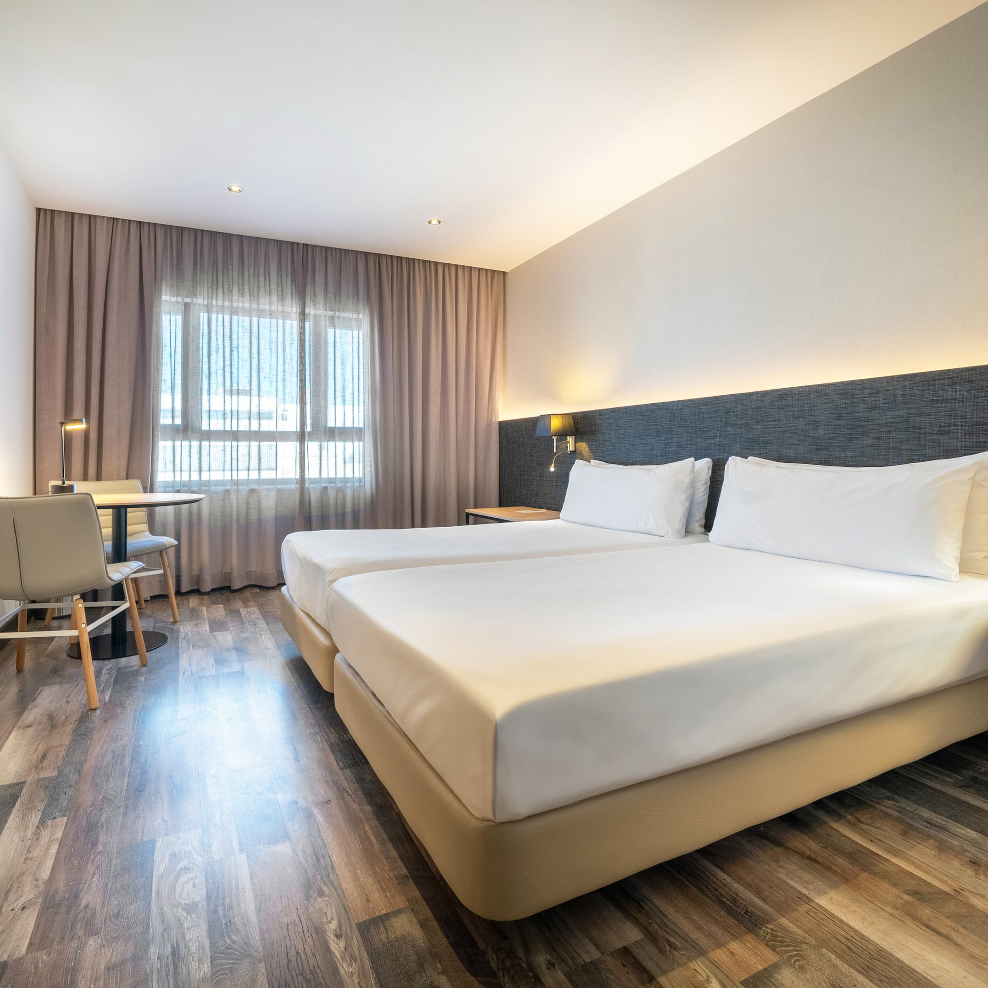 a room with two beds and a table