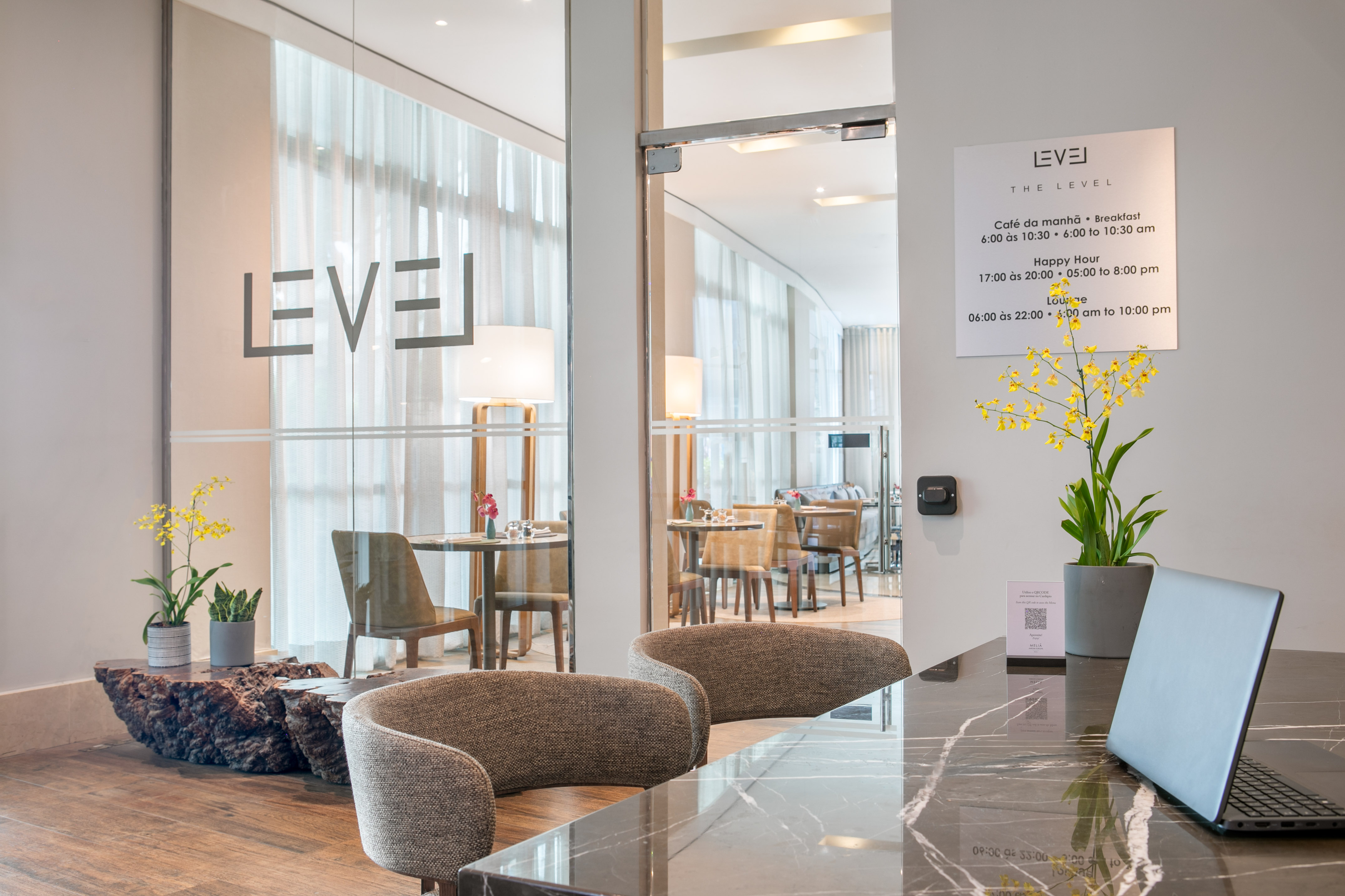 THE LEVEL hotel reception and lounge, modern design, service hours visible.