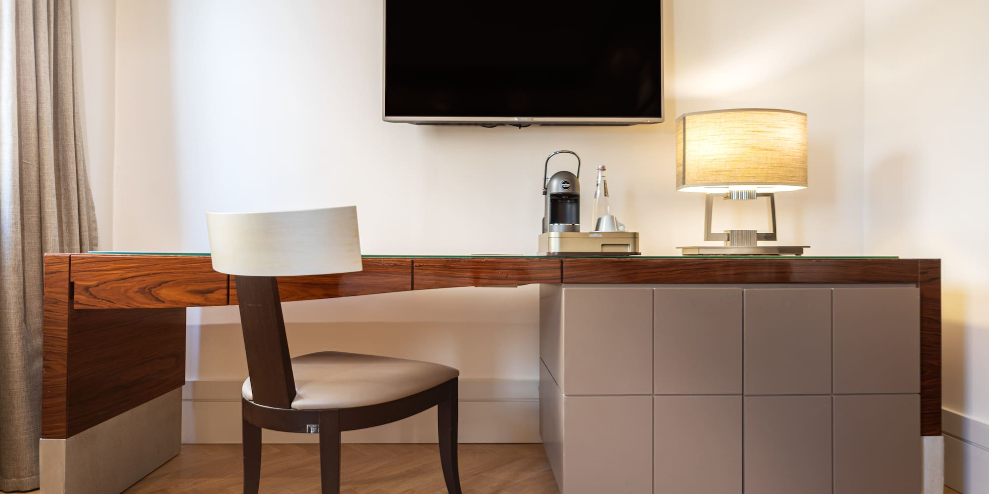 a desk with a chair and a tv on the wall