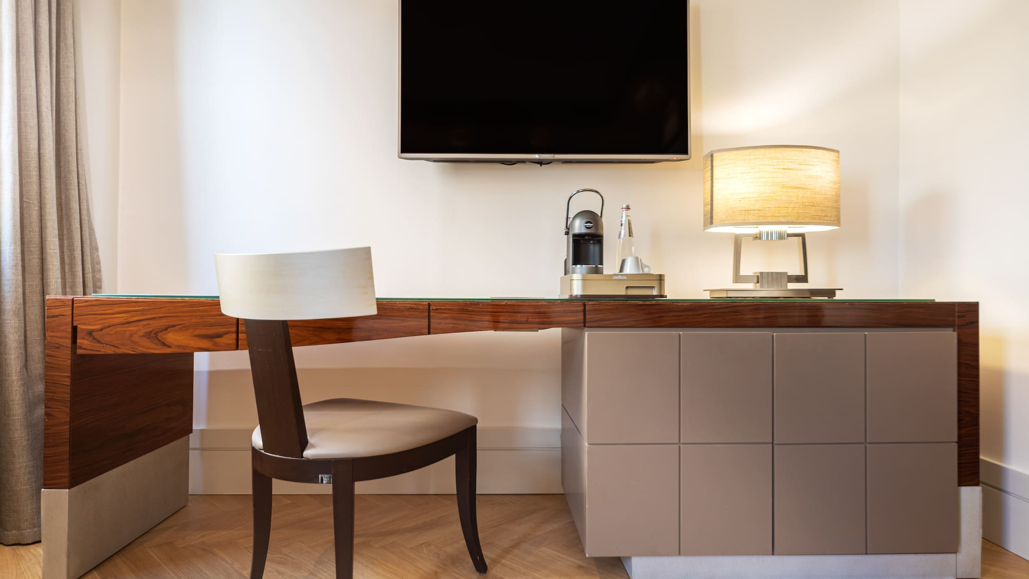 a desk with a chair and a tv on the wall