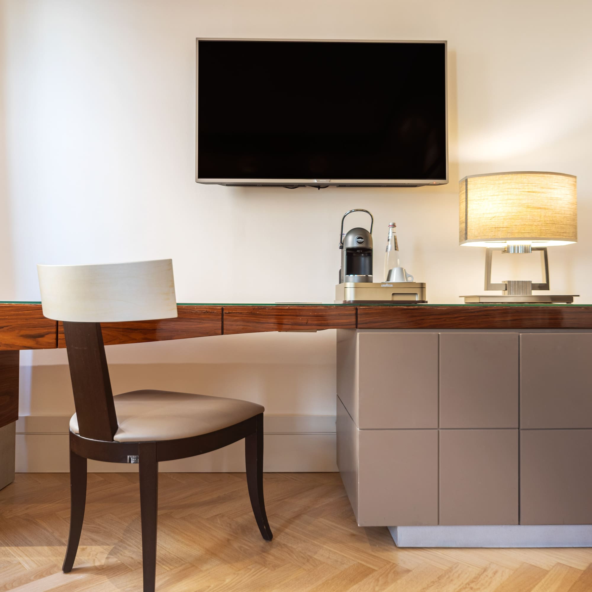 a desk with a chair and a tv on the wall