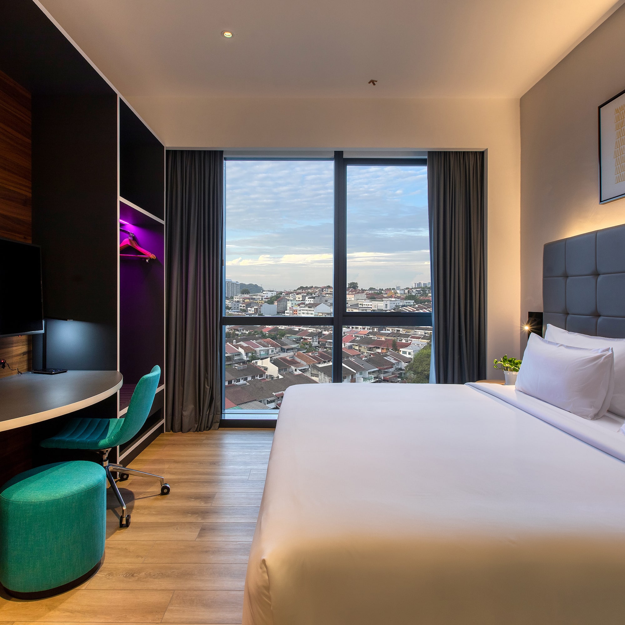 a room with a large bed and a desk and a window