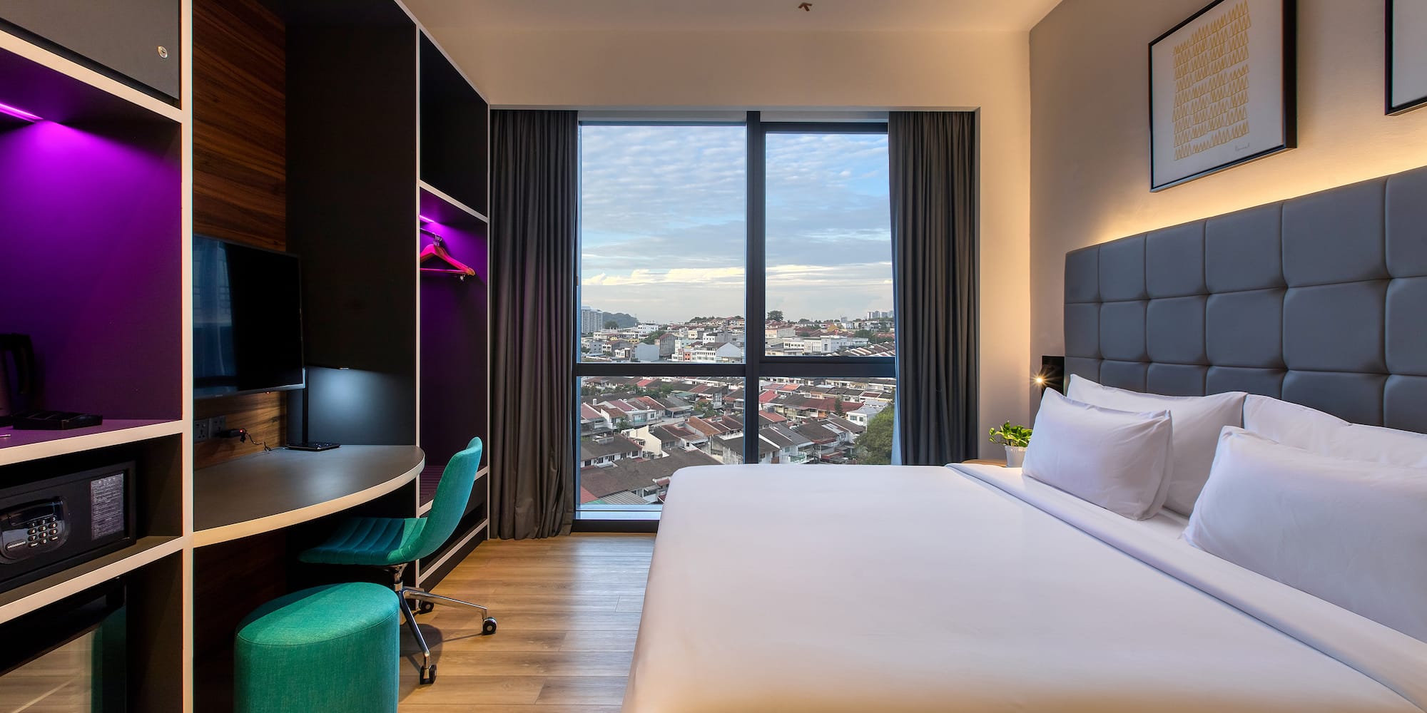 a room with a large bed and a desk and a window