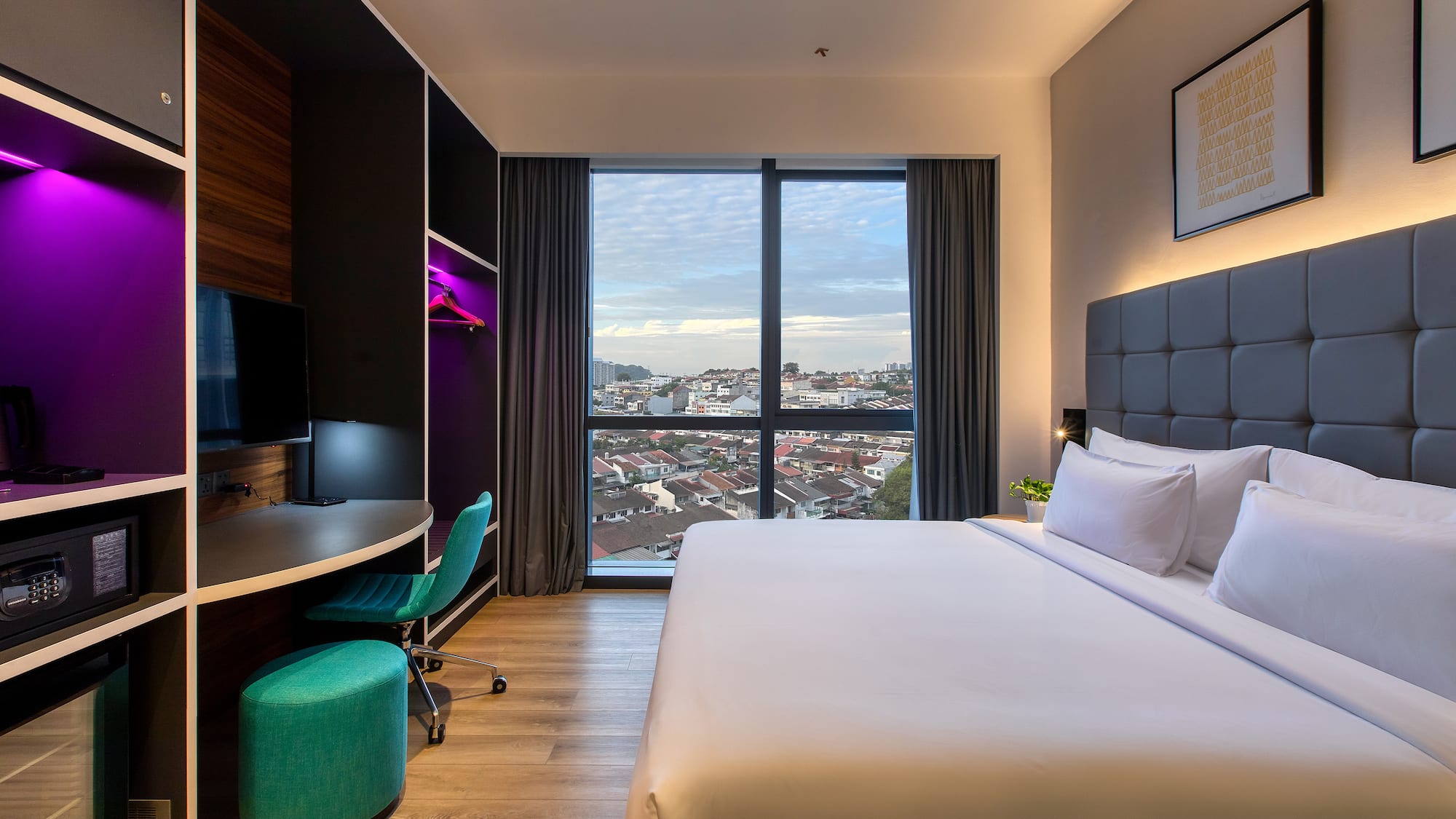 a room with a large bed and a desk and a window