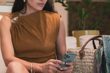 a woman sitting on a couch looking at her phone