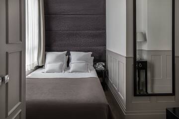 a bed with pillows and a mirror in the background