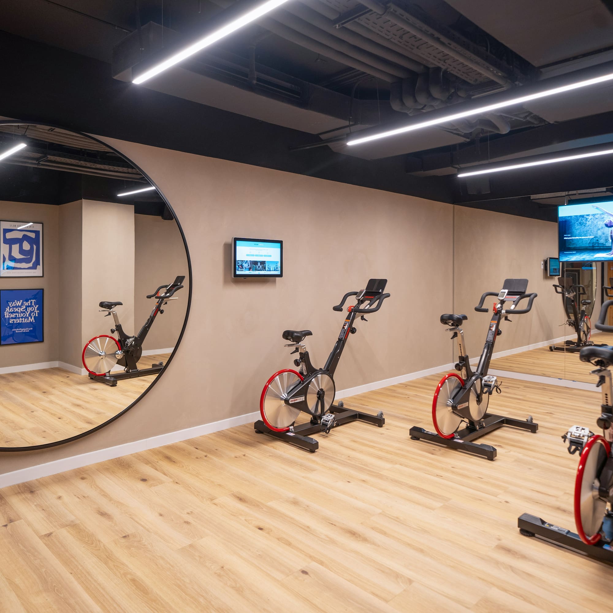 a room with exercise bikes and a mirror