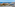 Coastal resort ocean view with sandy beach, marina, hotels, and blue sky.