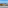 Coastal resort ocean view with sandy beach, marina, hotels, and blue sky.