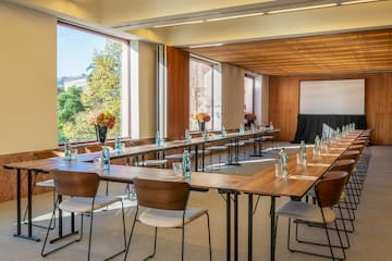 a room with tables and chairs and a screen
