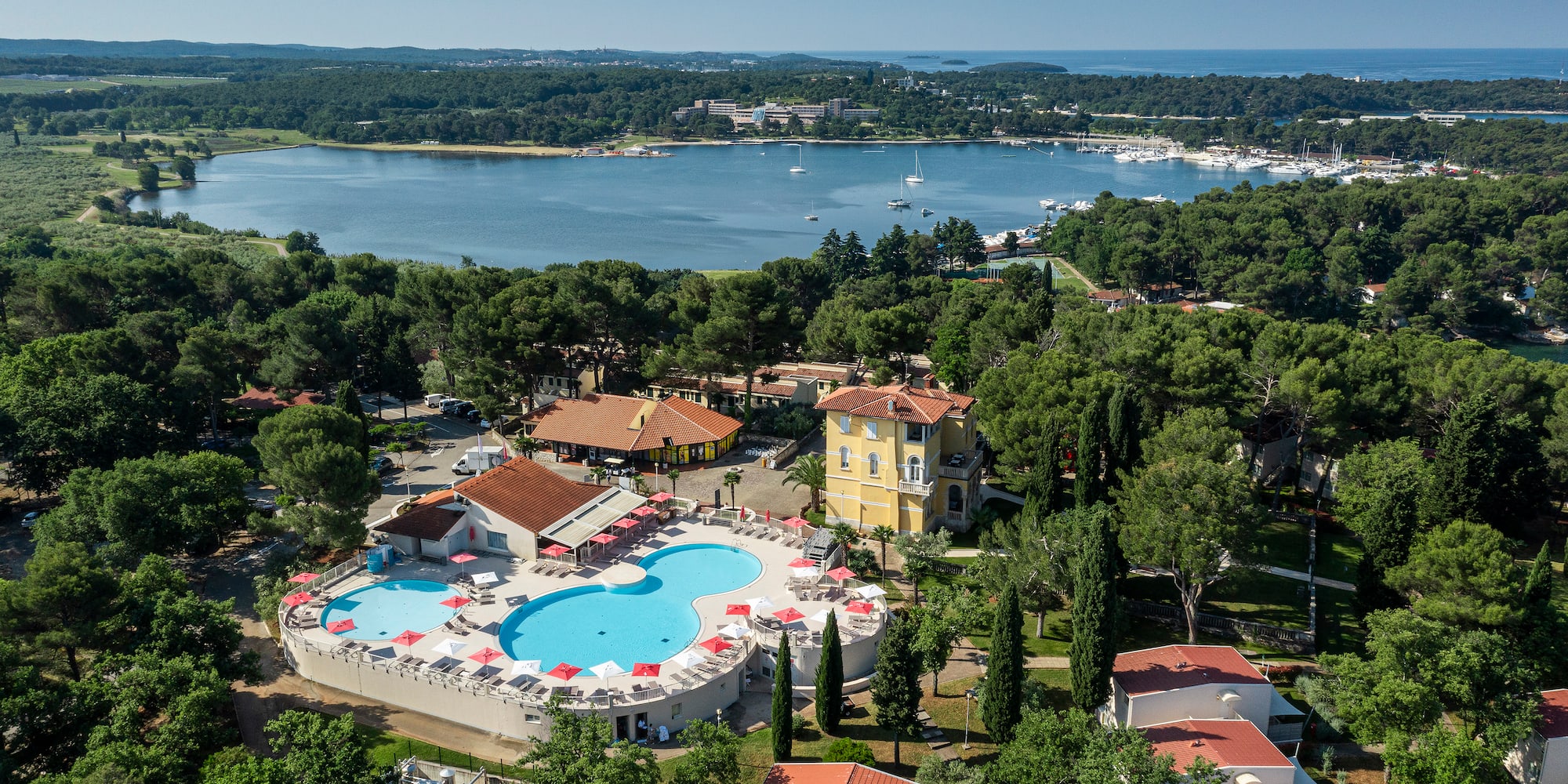 a pool and trees by a body of water