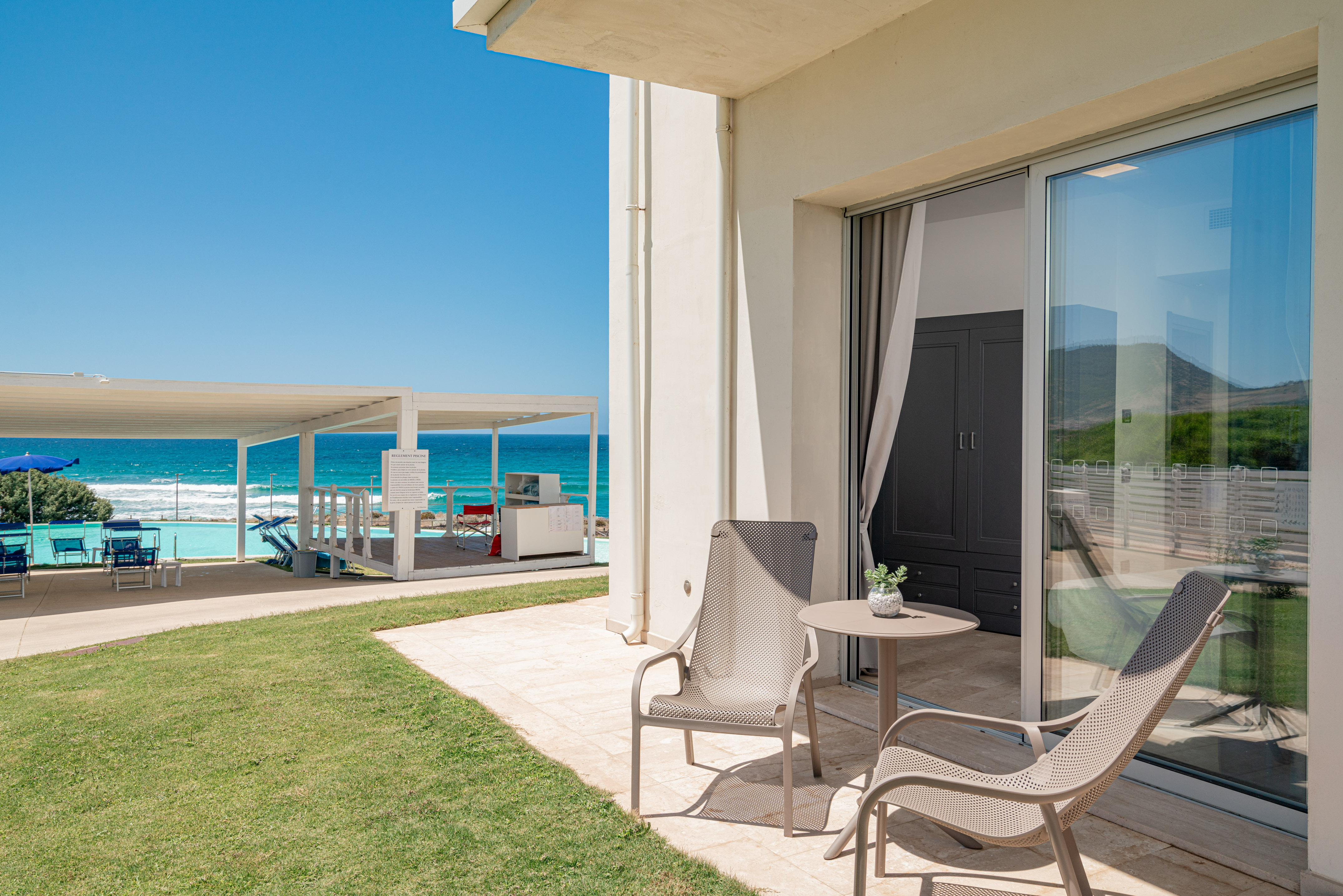 a patio with chairs and a table on the side of it