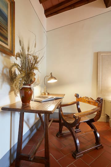 a desk with a plant and a lamp in a room