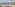 Luxury hotel infinity pool overlooking ocean, sun loungers, and umbrellas.