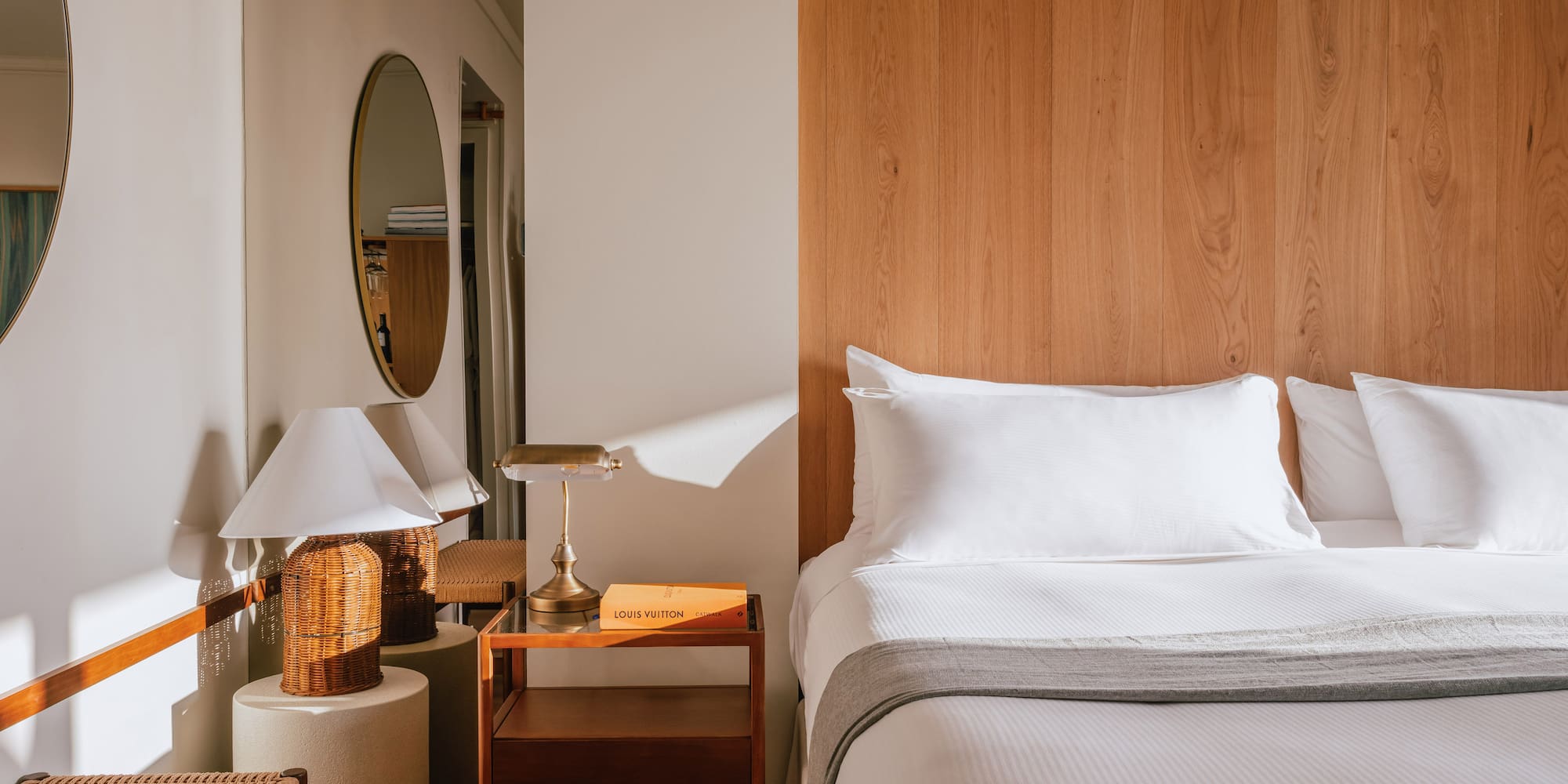 a bed with a wood headboard and a mirror