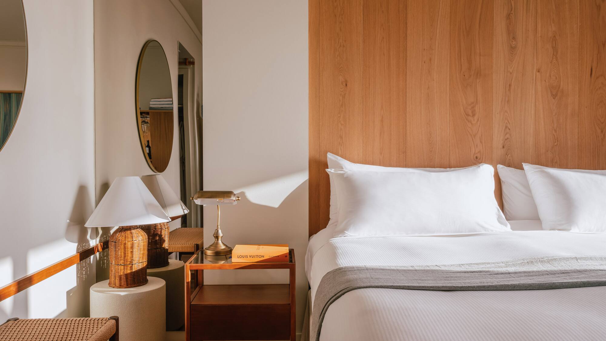 a bed with a wood headboard and a mirror