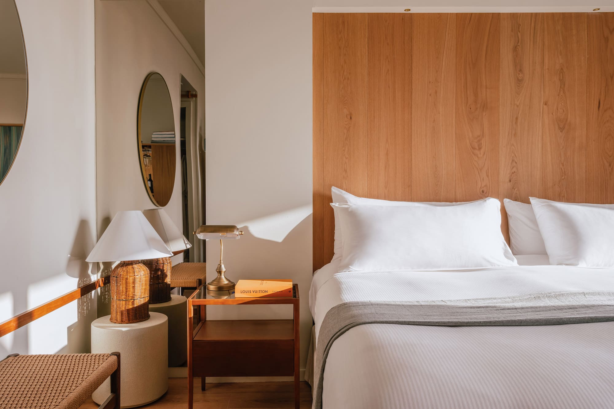 a bed with a wood headboard and a mirror