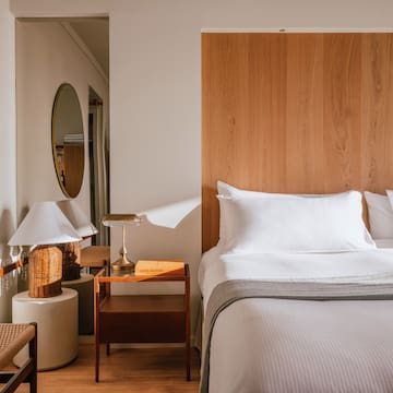 a bed with a wood headboard and a mirror