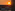 Orange sunset behind offshore wind turbines, urban riverfront, and skyscraper.
