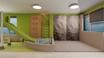 a room with a slide and a rock wall