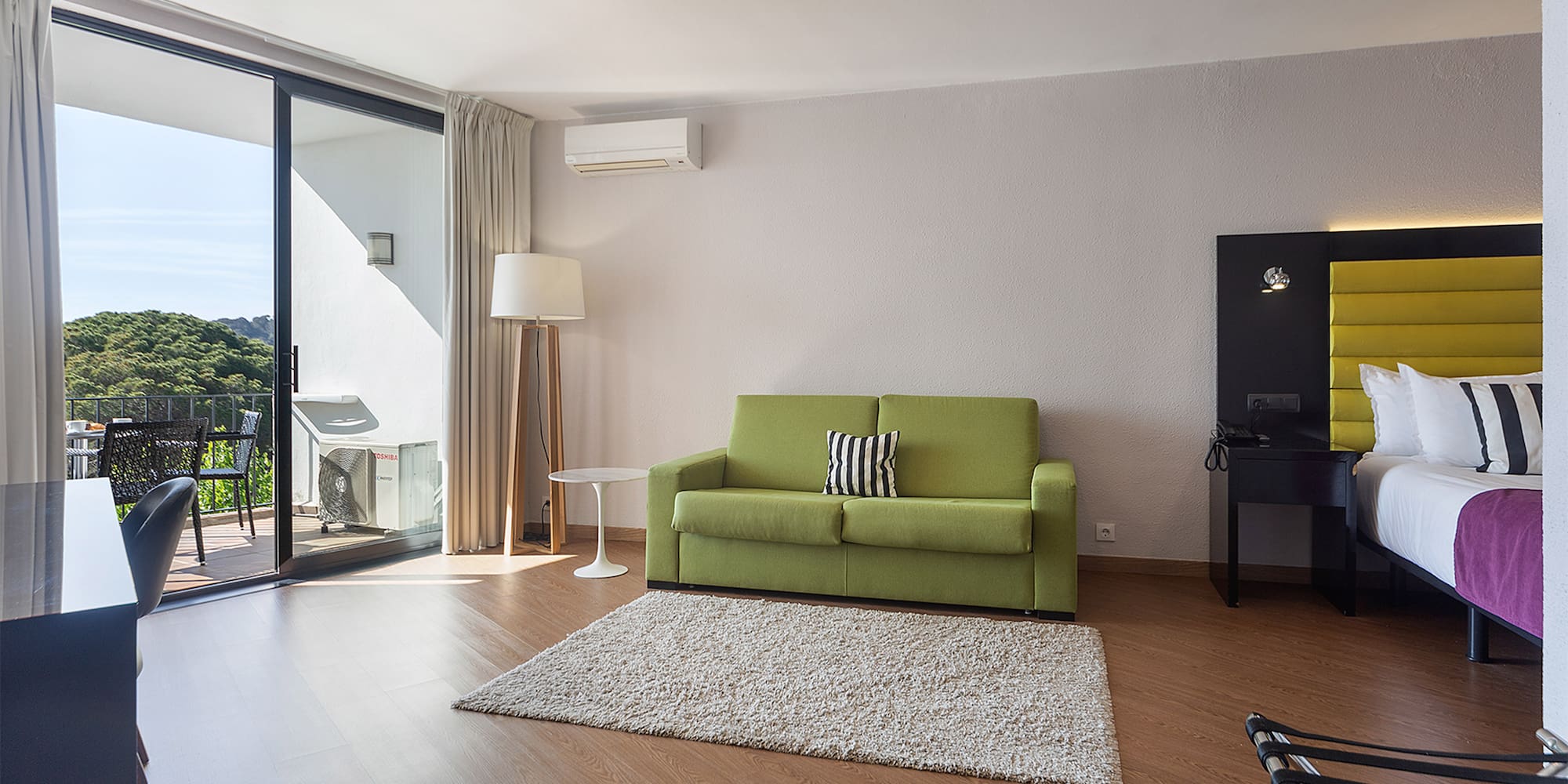 a living room with a green couch and a rug