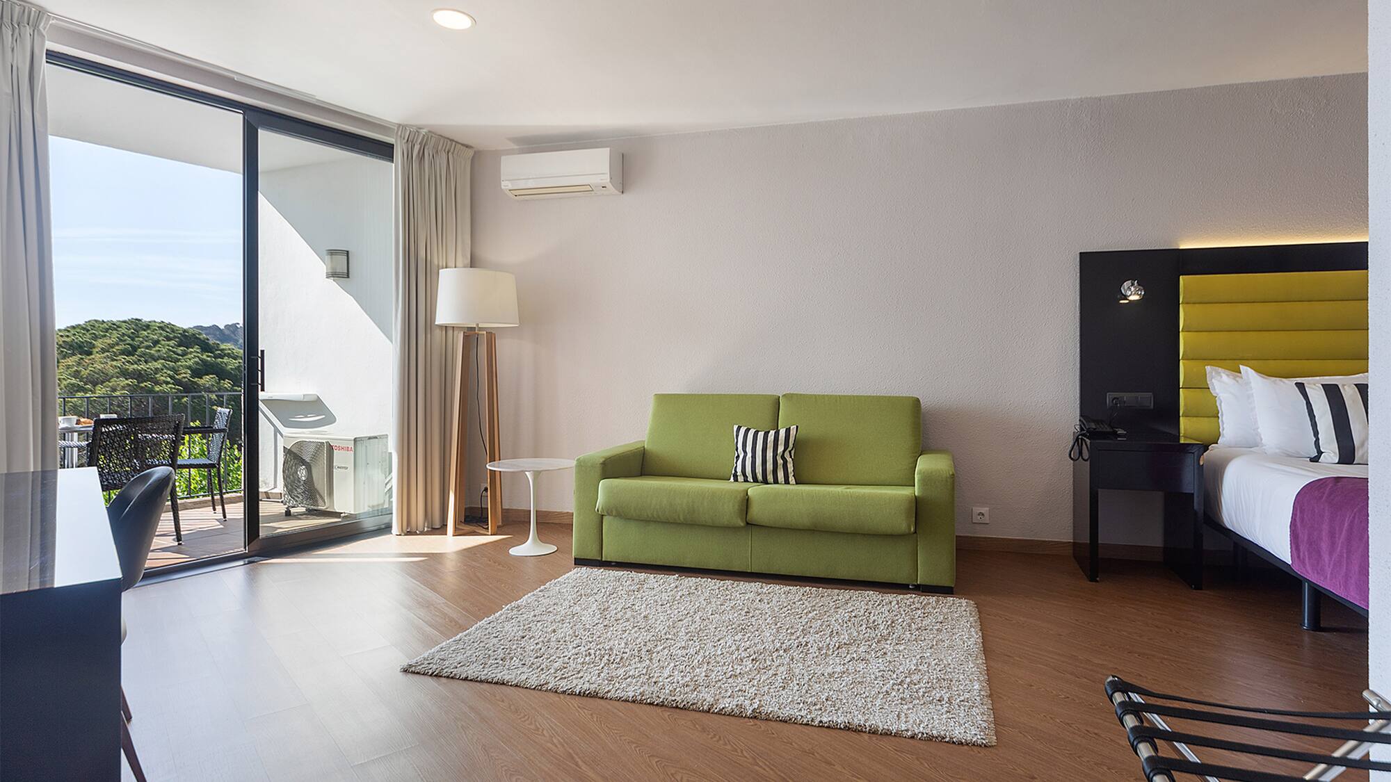 a living room with a green couch and a rug