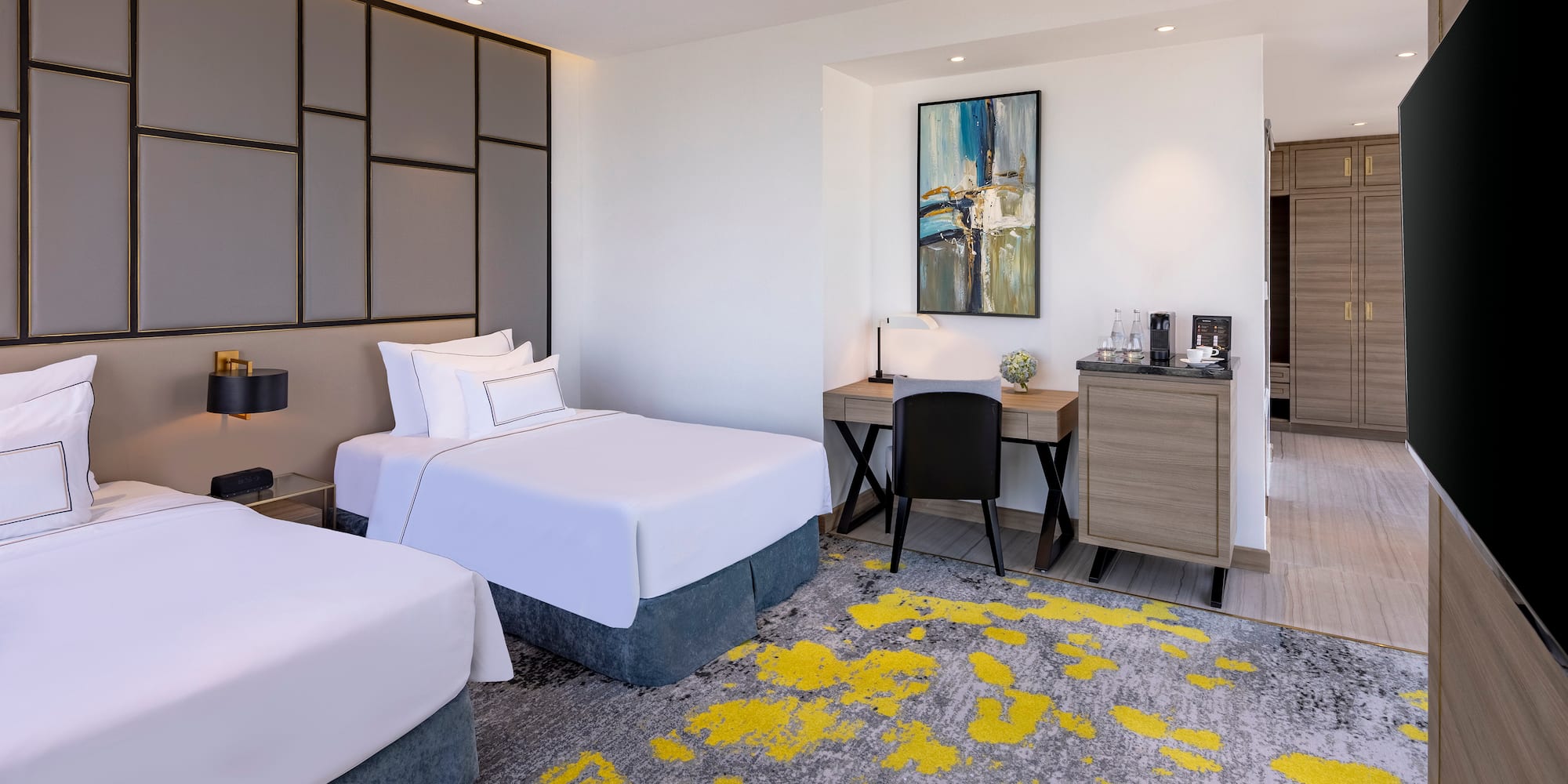 a room with two beds and a desk