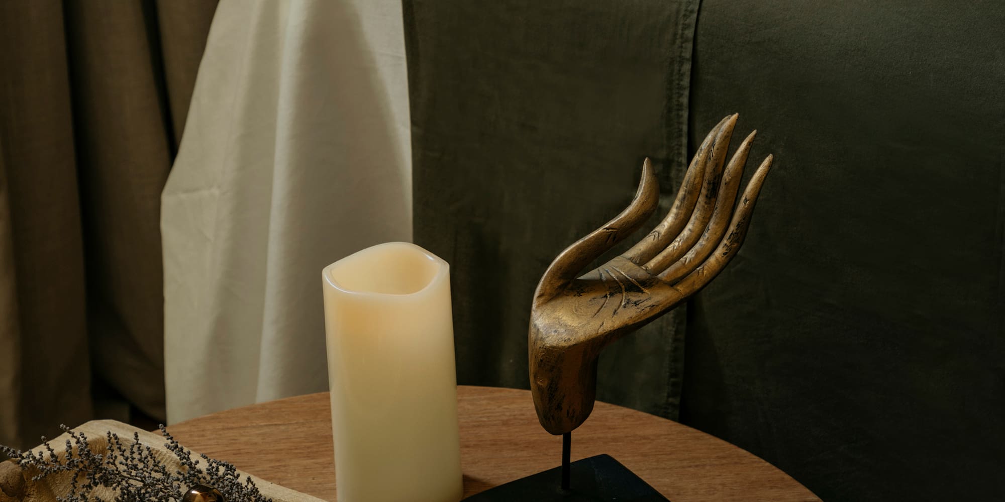 a table with a candle and a wooden tray with objects on it