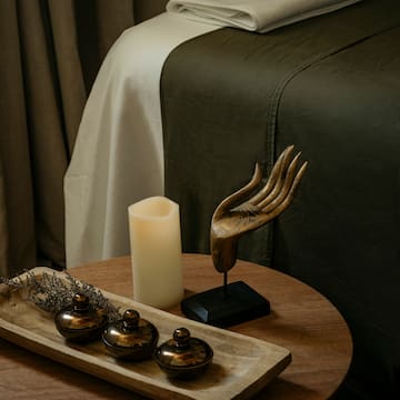 a table with a candle and a wooden tray with objects on it