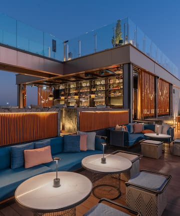 a rooftop bar with tables and chairs