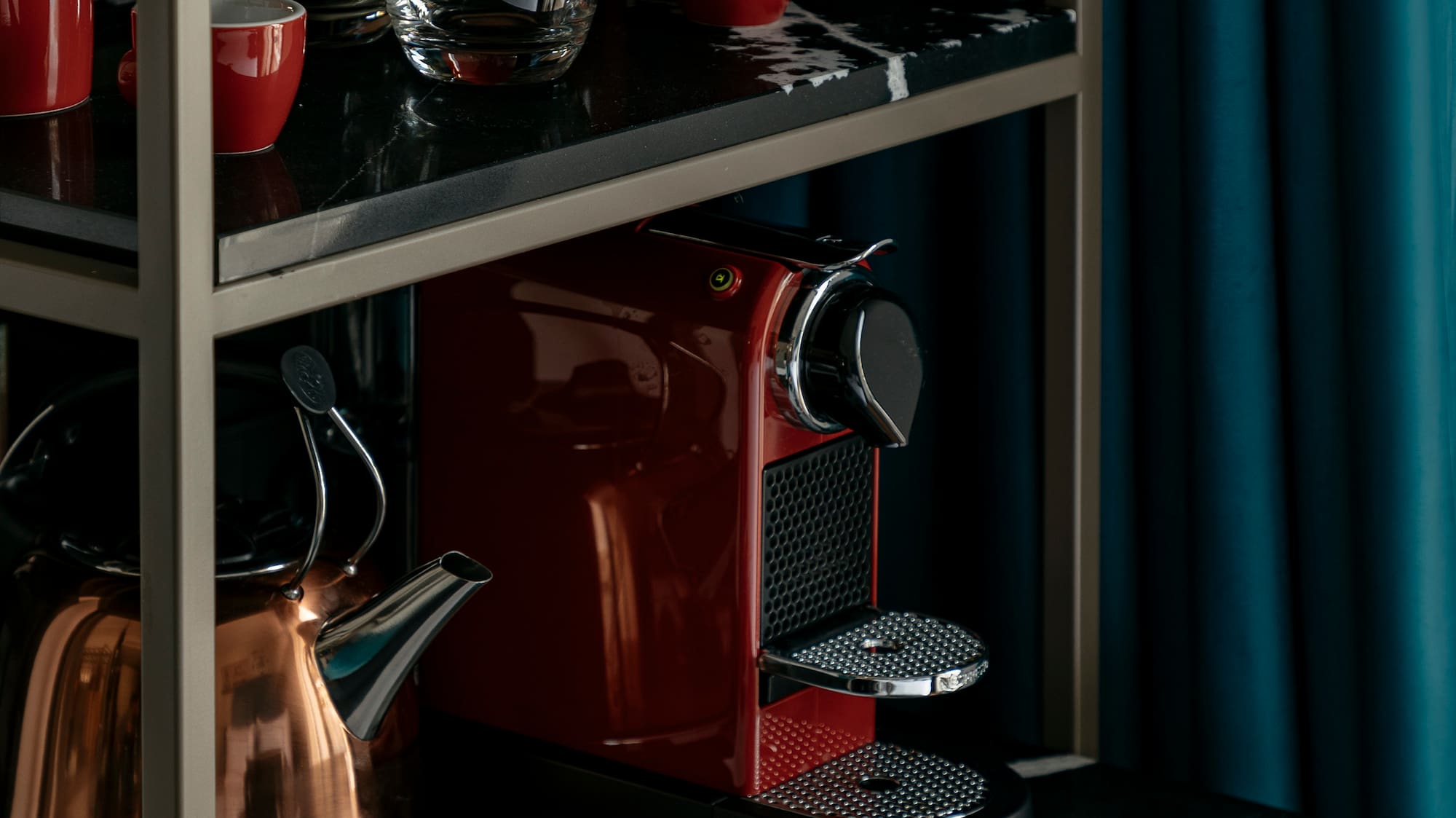 a coffee maker and cups on a shelf