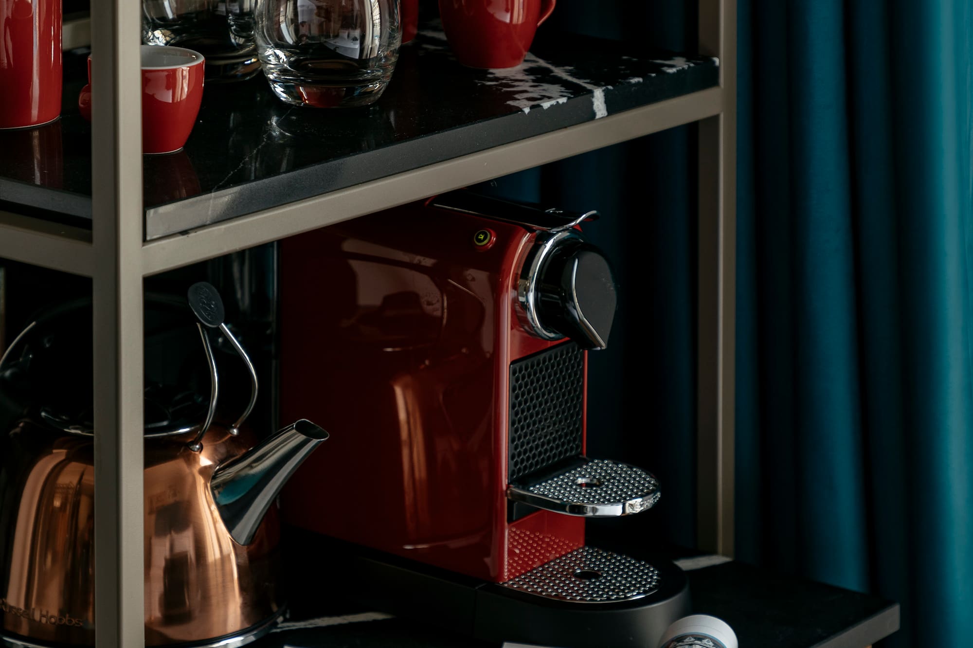 a coffee maker and cups on a shelf