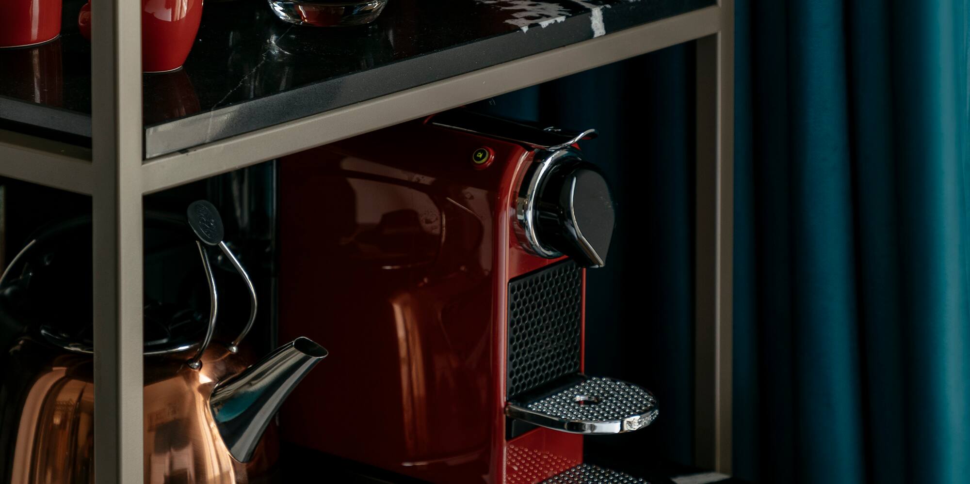 a coffee maker and cups on a shelf