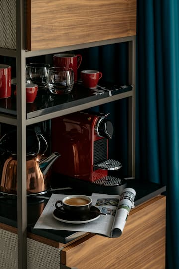 a coffee maker and cups on a shelf
