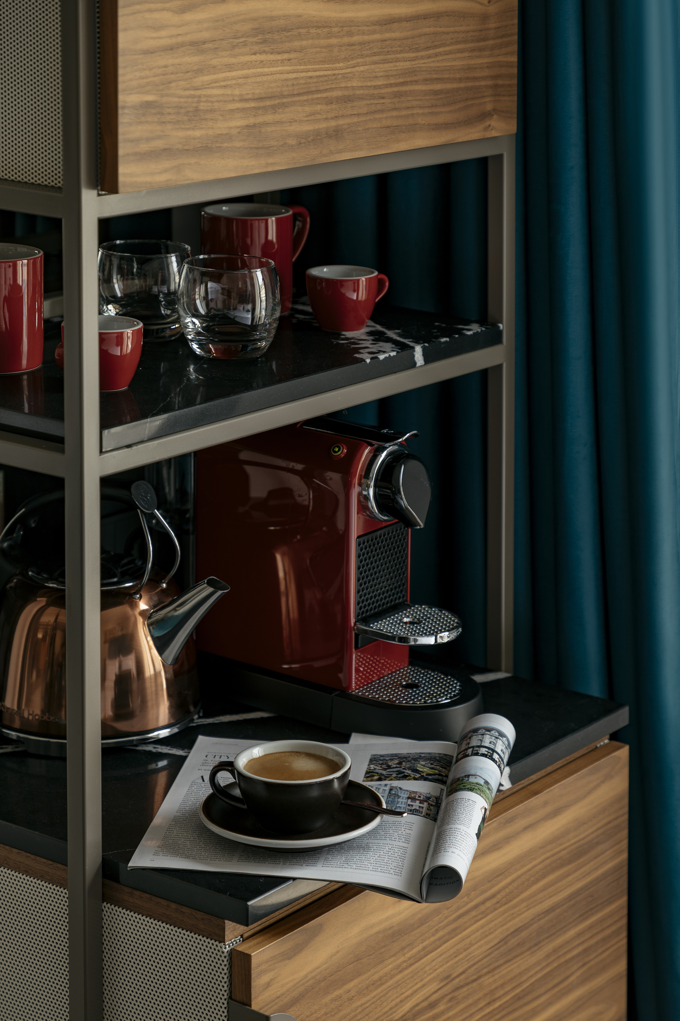 Stylish home coffee station with Nespresso machine, kettle, and coffee cup.